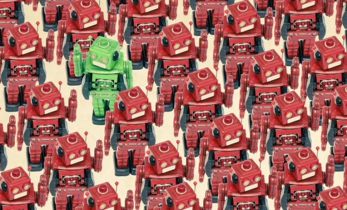 Group of red robots and one green roboto standing out from the crowd