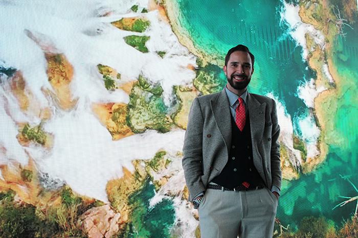 Professor Paolo Taticchi in a suit in front of a green and white patterned backdrop.