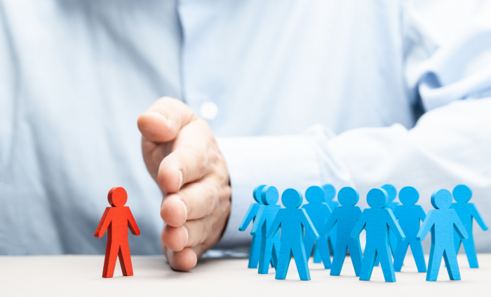 A hand divides a red figure from blue figures 